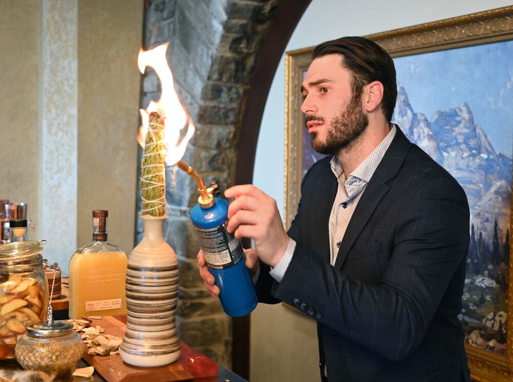 A bartender fires off a torch while making a fancy cocktail at the Banff Food & Cocktail Festival.
